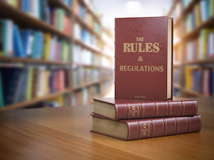 Rule books stacked up on a table in a library.